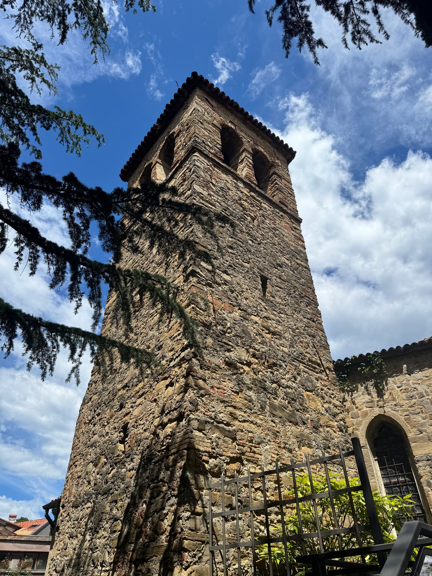 Kirchturm der San Franceso Kirche in Muggia aus Stein von unten nach oben fotografiert
