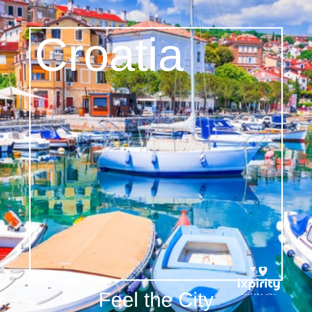 Der bunte Hafen von Opatija mit weißen Segelbooten vor pastellfarbenen Häuserfassaden an der kroatischen Adriaküste, Schriftzug Croatia und ixpirity Feel the City