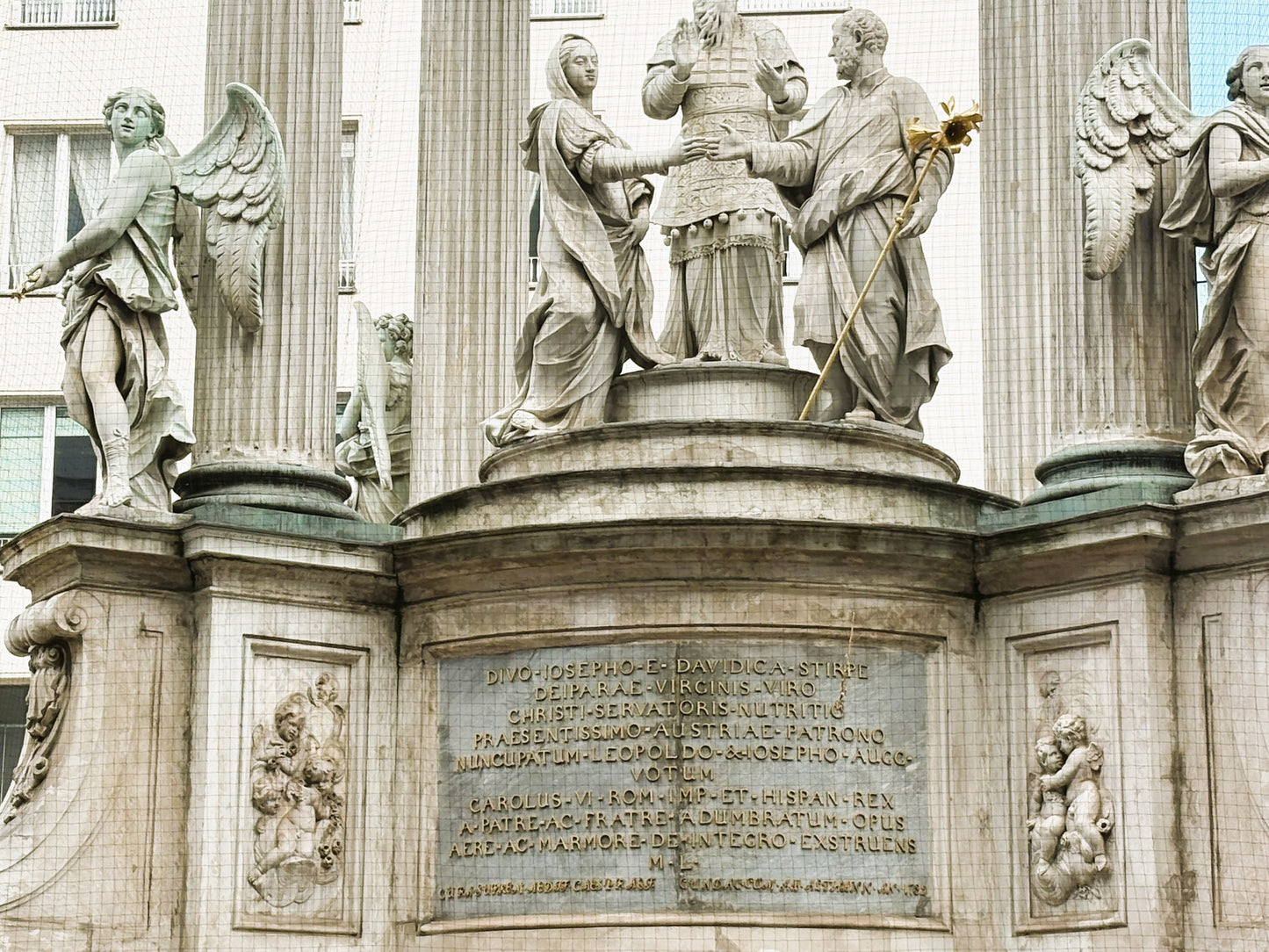 Eine Nahaufnahme einer der Skulpturen am Vermählungsbrunnen auf dem Hohen Markt in Wien.

Zu sehen ist ein muskulöser, bärtiger Mann in barockem Stil, der einen großen Krug (eine Amphore) hält, aus dem Wasser fließt.

Die Skulptur ist detailreich aus hellem Stein gearbeitet, wobei die dynamische Pose und die Gesichtszüge des Mannes im Fokus stehen.

Im Hintergrund ist die klassizistische Architektur des Brunnenaufbaus zu erkennen.