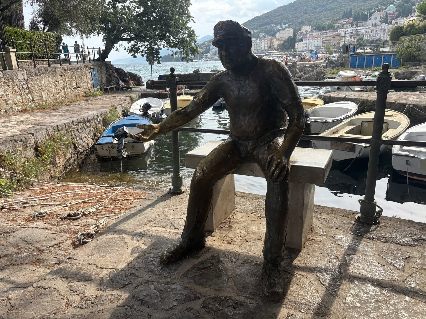 Die Bronzefigur des Barkajol, des Bootsmanns von Opatija, auf der Mole des kleinen Hafens Portić.