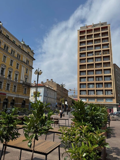 Der Jadranski trg in Rijeka mit dem Wolkenkratzer Neboder und den Fontänen auf dem Platz.