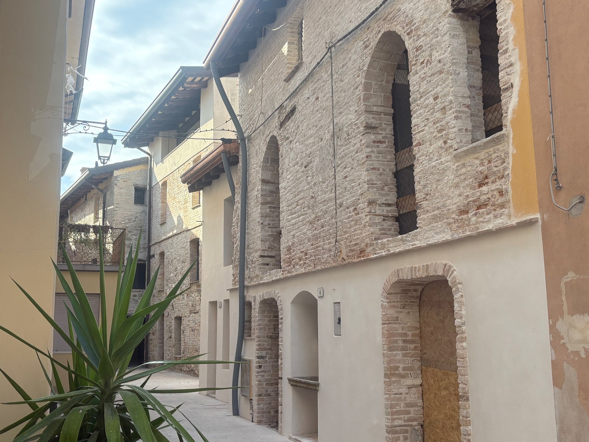 Schmale Gasse in Marano Lagunare mit freigelegten gotischen Bogenfenstern und Bogentüren in altem Ziegelmauerwerk