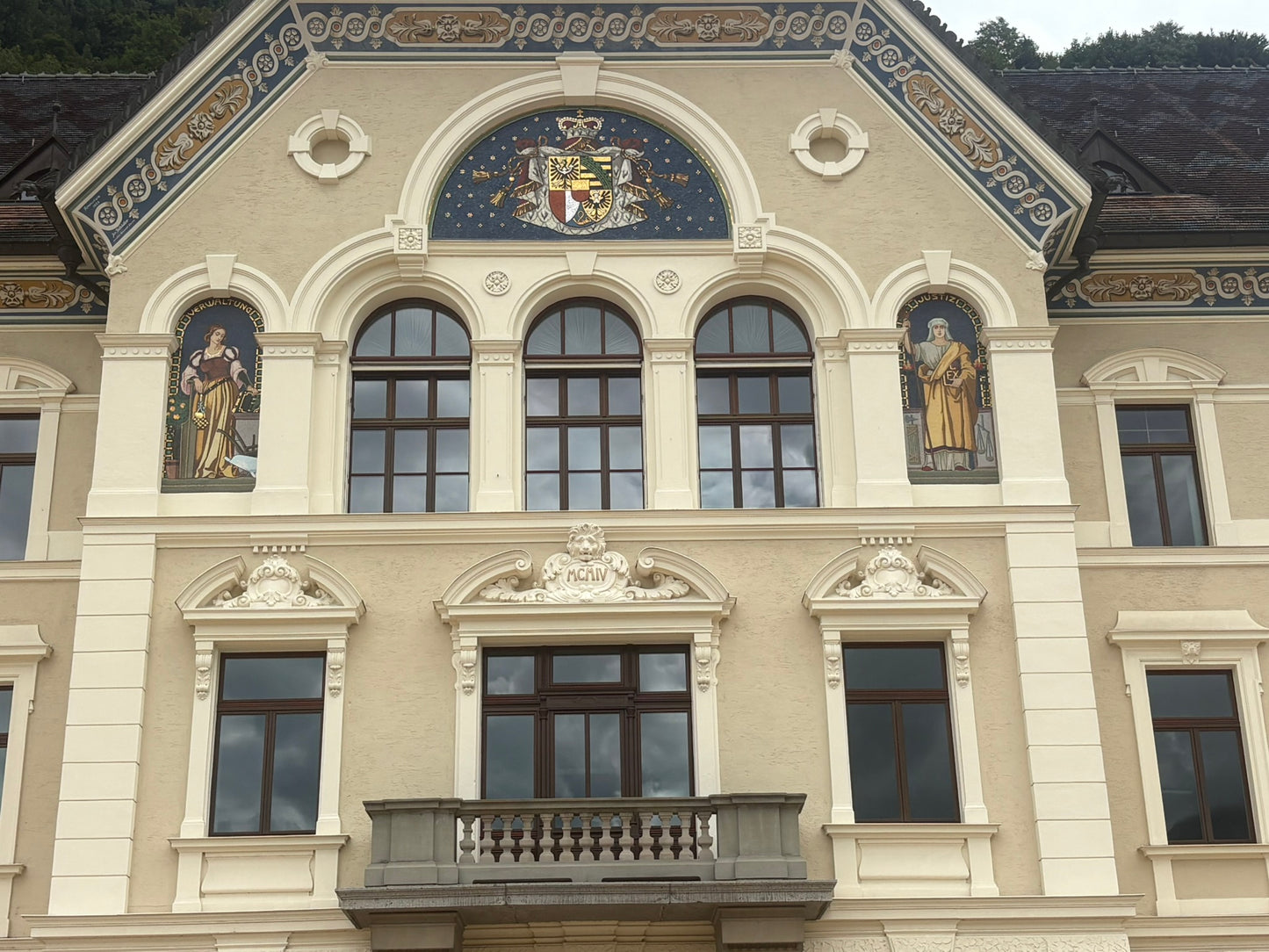 Liechtenstein's government building in Vaduz with the national coat of arms and frescoes