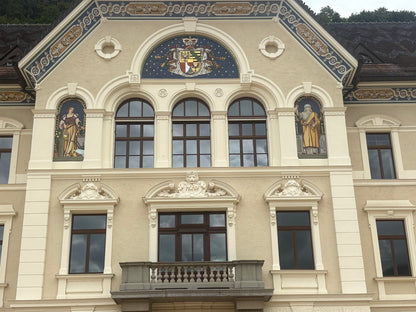 Liechtenstein's government building in Vaduz with the national coat of arms and frescoes