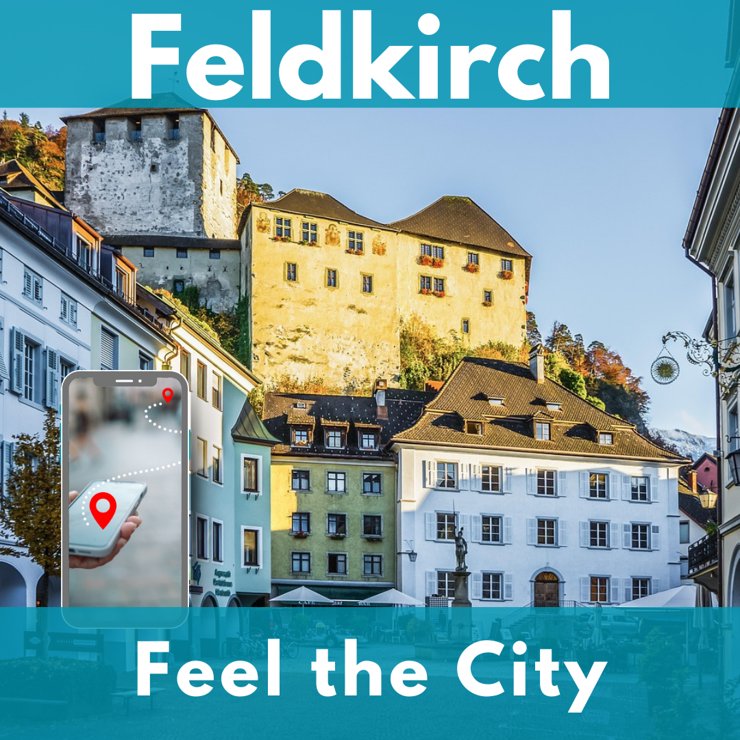 Il castello Schattenburg sopra le case colorate del centro storico di Feldkirch. In primo piano a sinistra uno smartphone con un percorso tra due punti rossi.