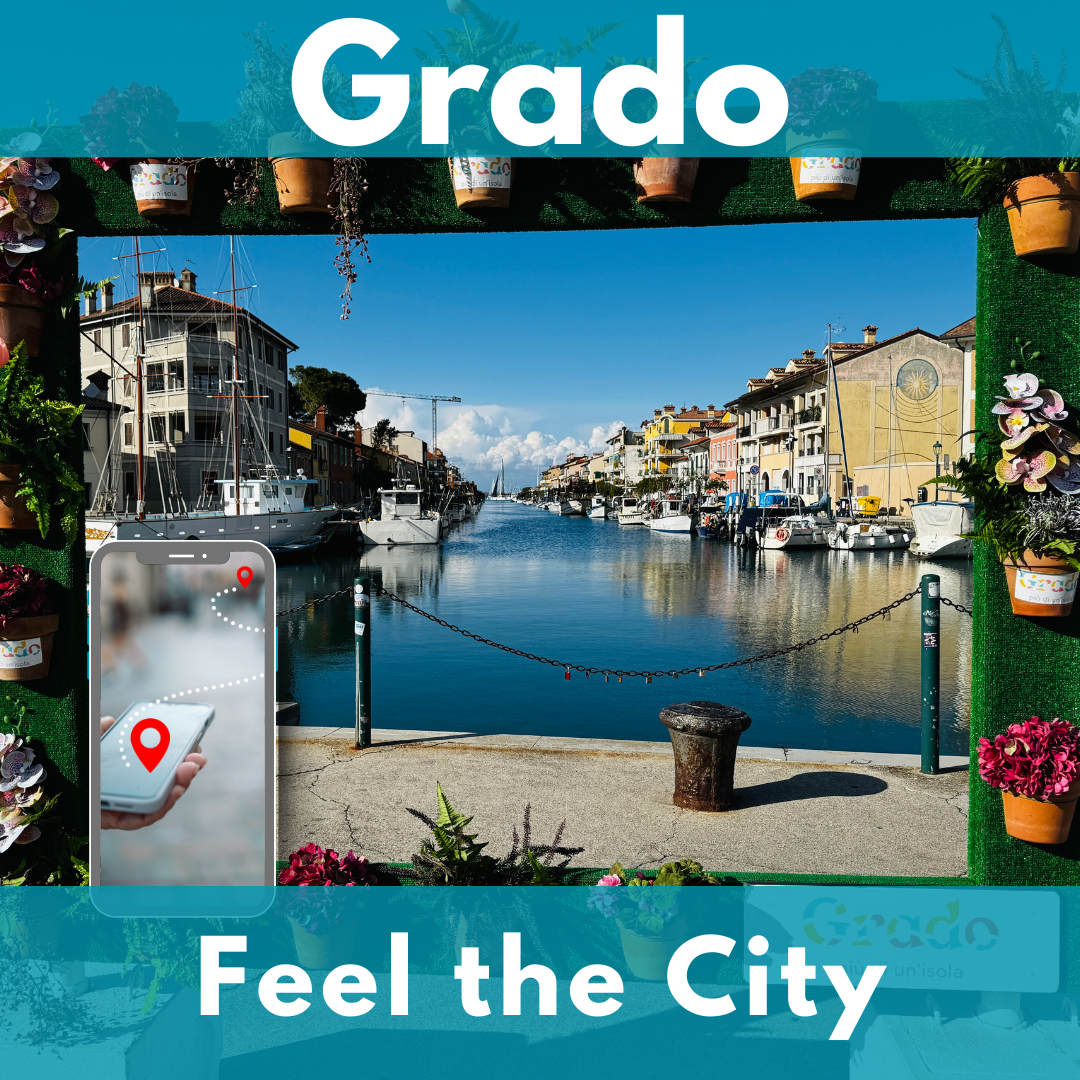 Vista attraverso una cornice fiorita sul canale di Grado con barche e case colorate. In primo piano a sinistra uno smartphone con un percorso tra due punti rossi.