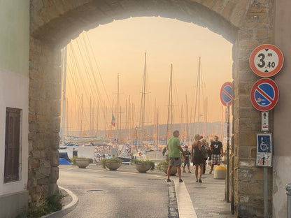 View through the old town gate onto Muggia's harbour in the evening sun